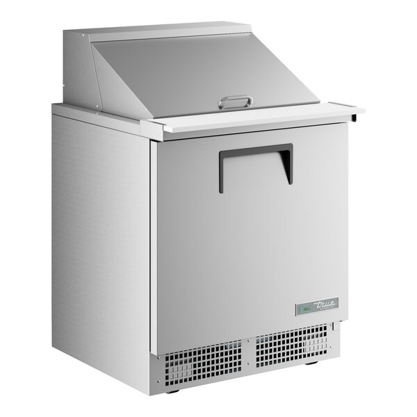 A stainless steel True refrigerator with an open door.