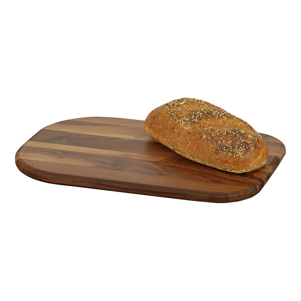 A loaf of bread on a walnut wooden serving board.