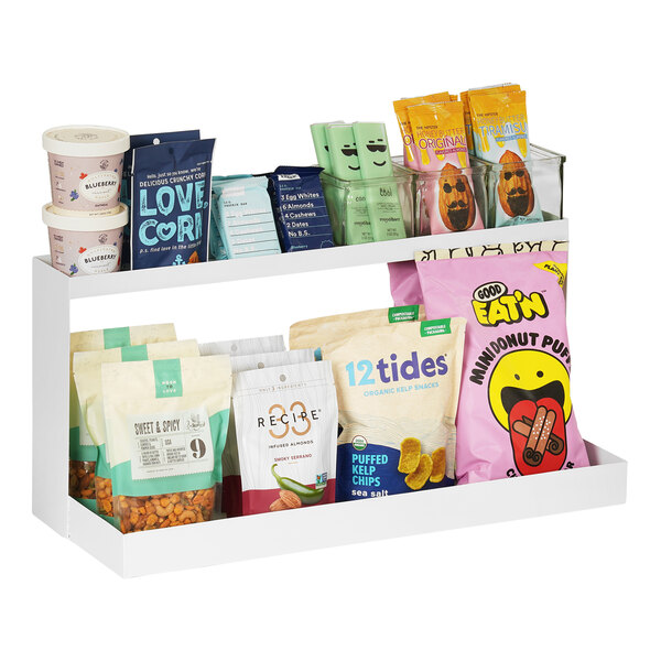 A white metal Juno counter merchandiser with snacks on the shelves.