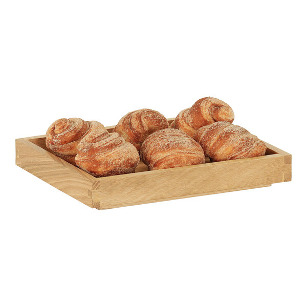 A Cal-Mil oak display box with pastries on a table in a bakery.