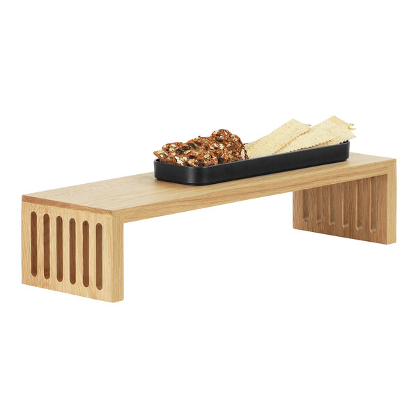 A Cal-Mil oak nesting display stand holding a tray of food.