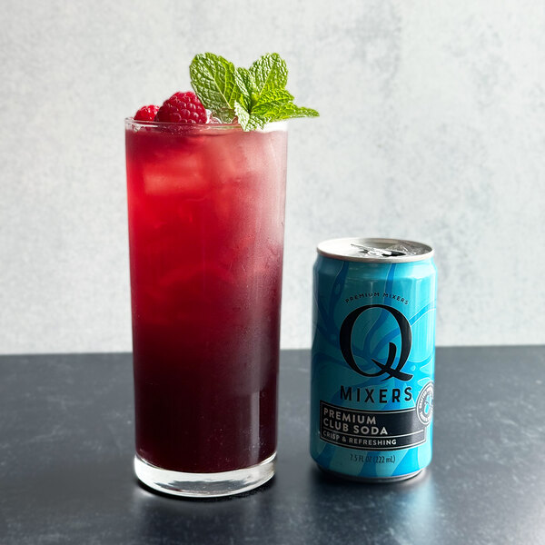 A can of Q Mixers Club Soda next to a glass of red liquid.