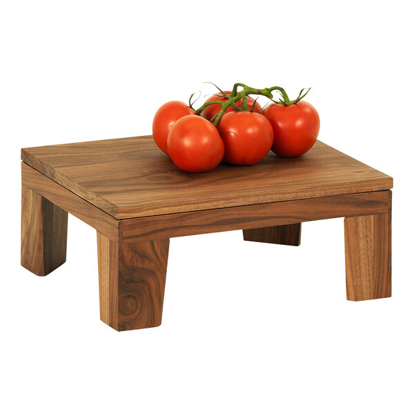 A group of tomatoes on a vine displayed on a Cal-Mil walnut display stand.