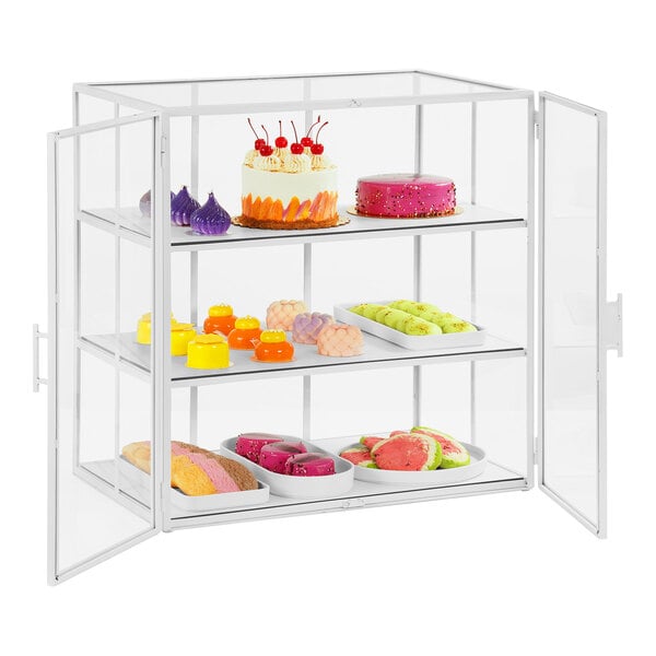 A white Cal-Mil metal bakery display case with food on shelves.