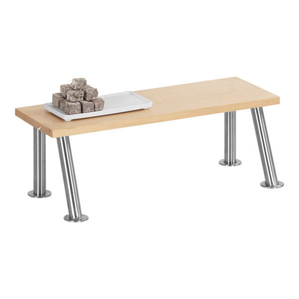 A Cal-Mil maple rectangle display stand with stainless steel legs holding brown sugar cubes on a table.