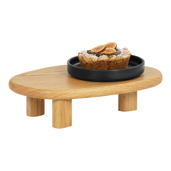 A Cal-Mil oak display stand with a dessert on it.