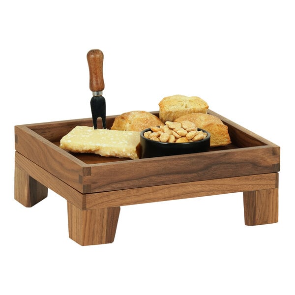 A Cal-Mil walnut display stand with food on a table.