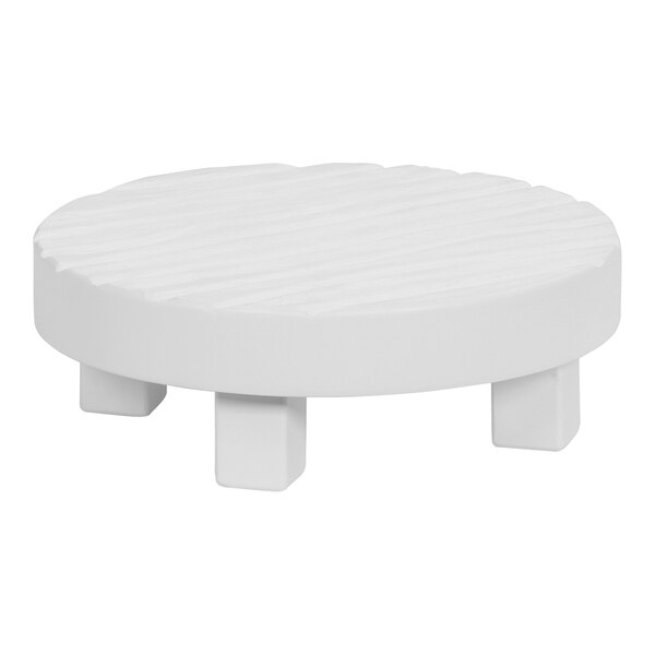 A white wood round display stand with legs on a white table.