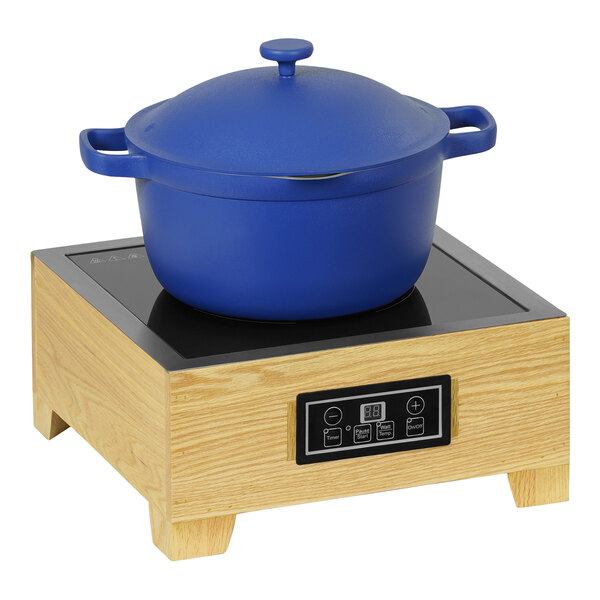 A blue pot on a wooden countertop induction burner.