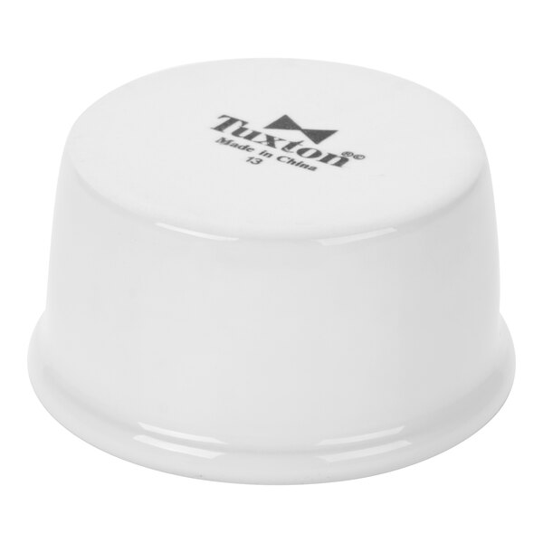 A small white smooth china ramekin turned upside down.
