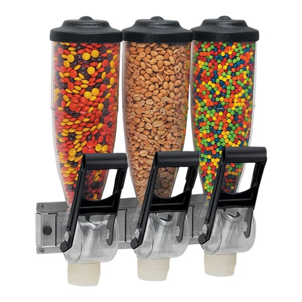A Server triple canister dry food and candy dispenser on a counter full of candy.