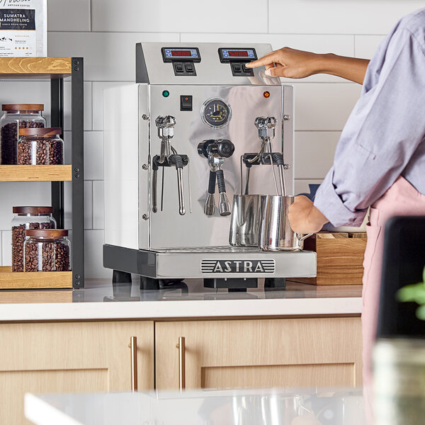 An Astra STA4800-WH gloss white automatic milk and beverage steamer with two wands on a countertop.
