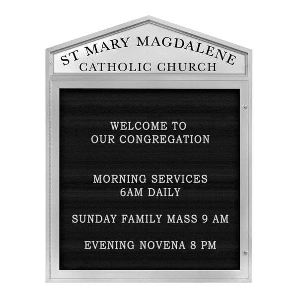 A white United Visual Products outdoor letterboard sign with black text that says "St. Mary Macadamian Catholic Church" and has a pointed header.