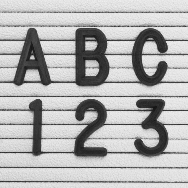 A close-up of a piece of paper with black United Visual Products Helvetica letters that spell "abc" and "123"