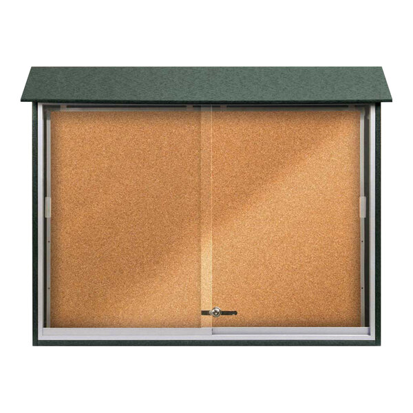 A cork board with a glass door and a green frame.