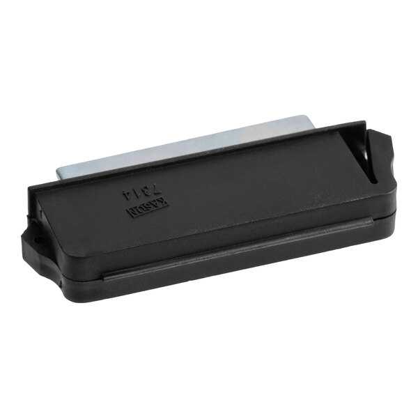 A rectangular black plastic component with a visible metal piece partially inserted, likely a magnet or latch part.