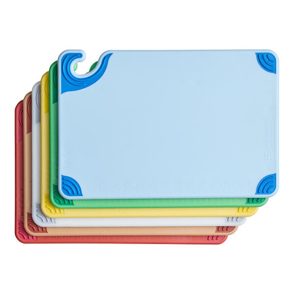 A set of six color-coded plastic cutting boards stacked together.