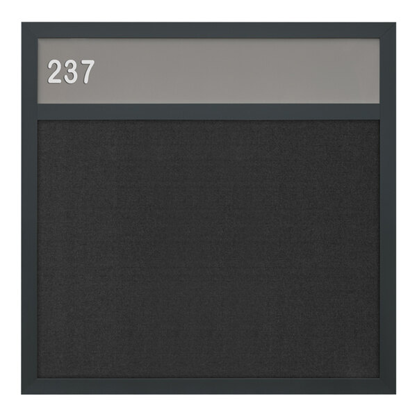 A black board with a black frame and black felt with white numbers on it.