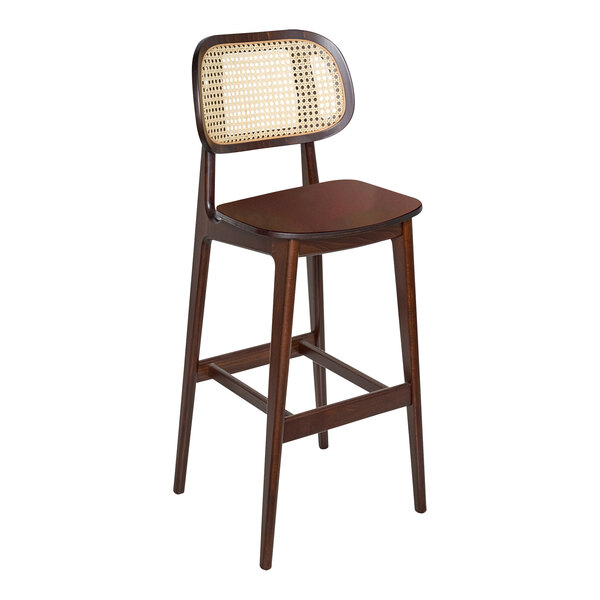 A BFM Seating Emma dark walnut wooden barstool with a cane back and veneer wood seat.