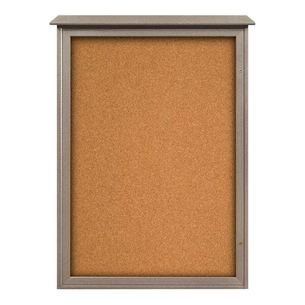 A cork board with a weathered wood frame and a glass door.