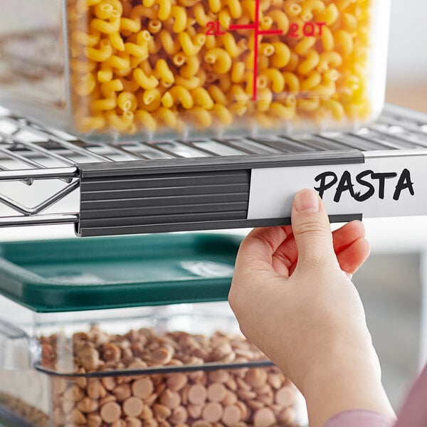A hand holding a Regency gray label over a container of pasta.