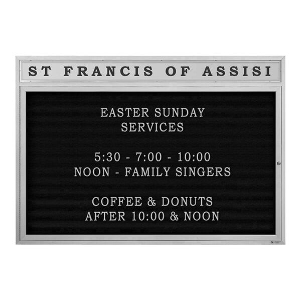 A black sign with white text on a white background inside a black board with the words "Saint Francis of Assisi" above it.