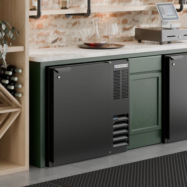 A black underbar height solid door back bar refrigerator designed for commercial use.