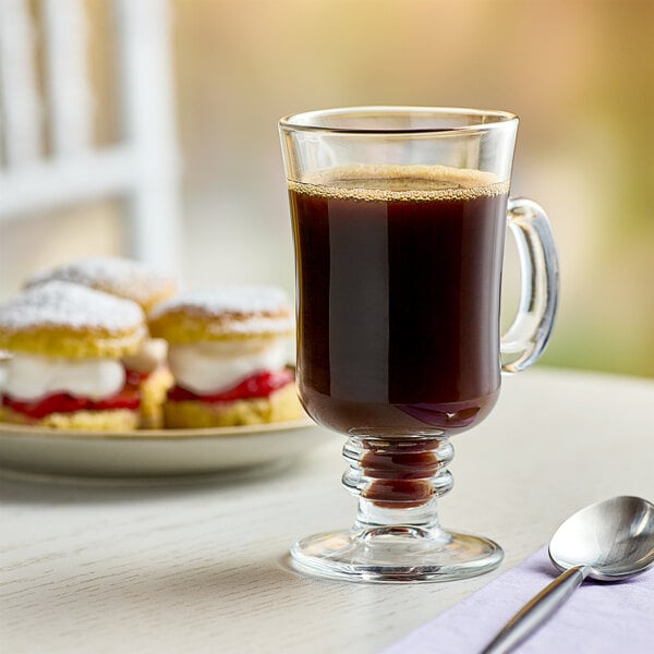 A glass of Cafe Bustelo Espresso coffee on a table with pastries.