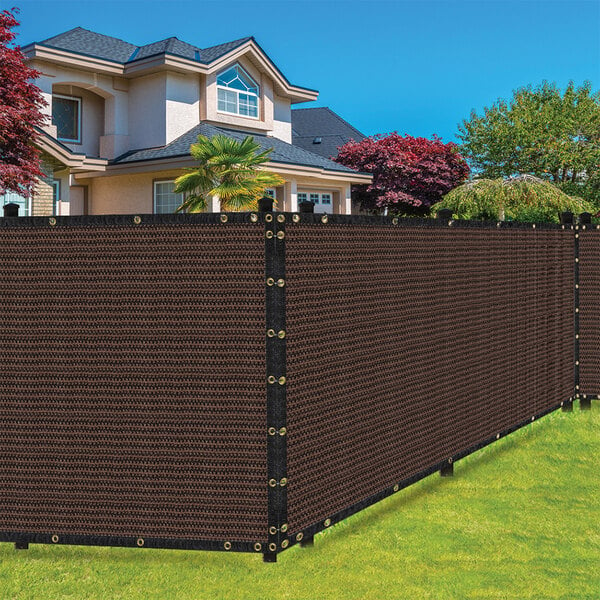 A large brown privacy fence screen in front of a house.