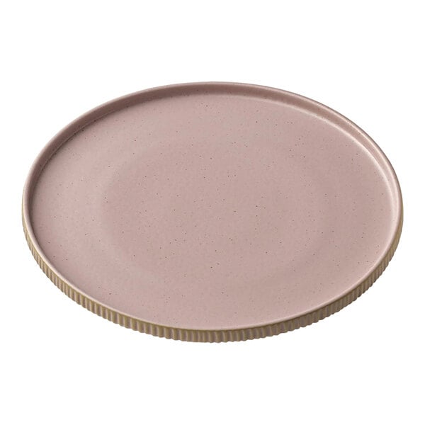 A round pink stoneware plate with a high gold rim.