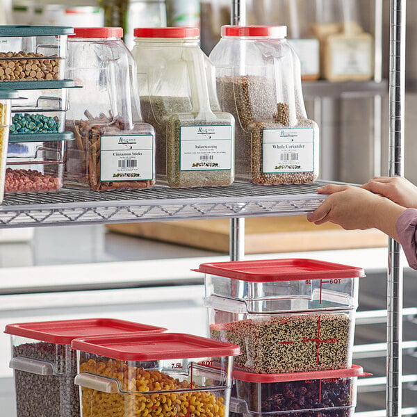 A woman using a Regency clear label holder on a shelf with plastic containers of grains.