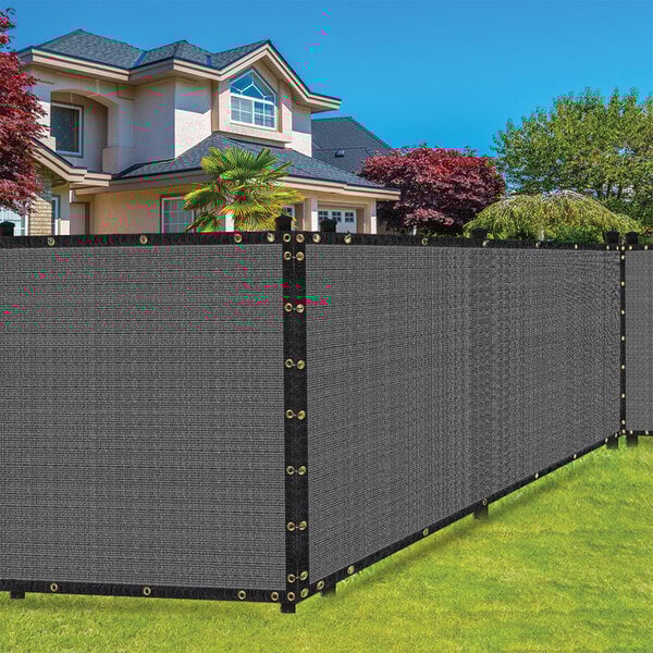 A gray SEALTECH privacy fence screen on a black fence in front of a house.