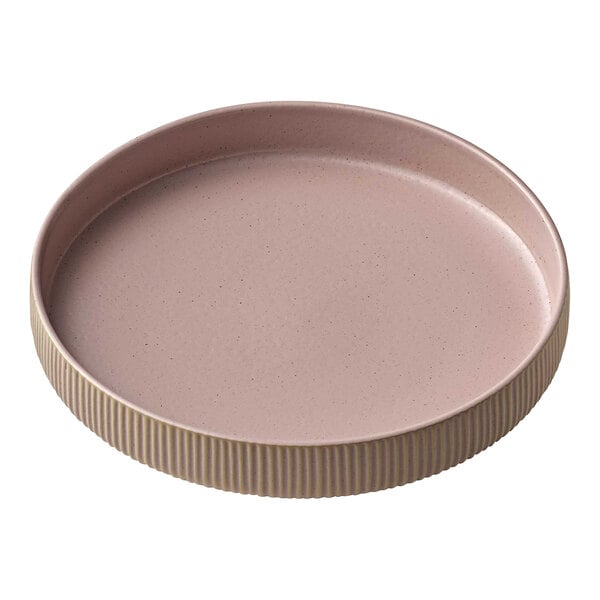 A round pink stoneware plate with a brown rim.