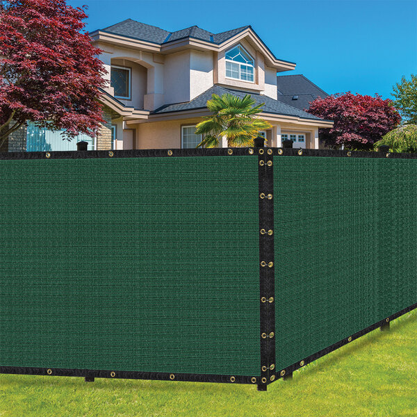 A green SEALTECH privacy fence screen on a green fence in front of a house.