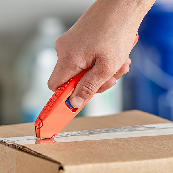 A hand using an Allway Tools Aluminum Safety Knife to cut a box.