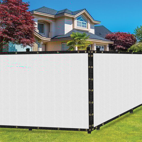 A white SEALTECH polyethylene mesh privacy fence screen on a fence in front of a house.