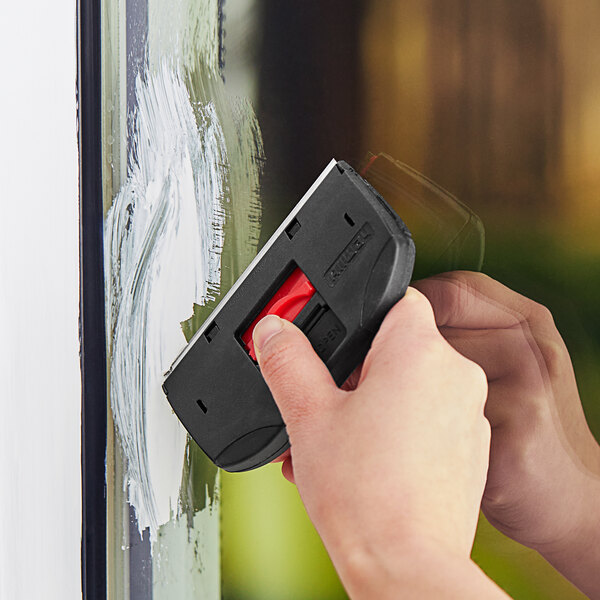 A person using an Allway Tools glass scraper to clean a window.