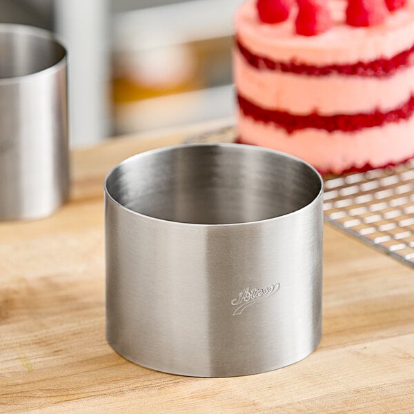 A round stainless steel cylinder on a wood surface.