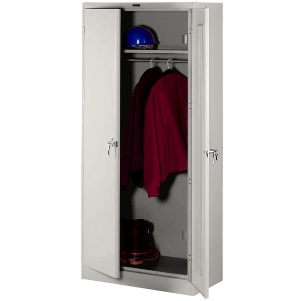 A light gray metal Tennsco wardrobe cabinet with solid doors.