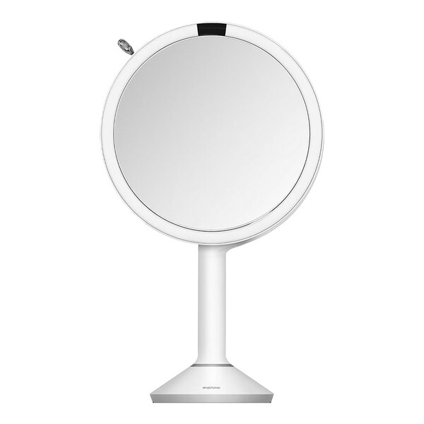 A round white stainless steel sensor mirror with a black stand.