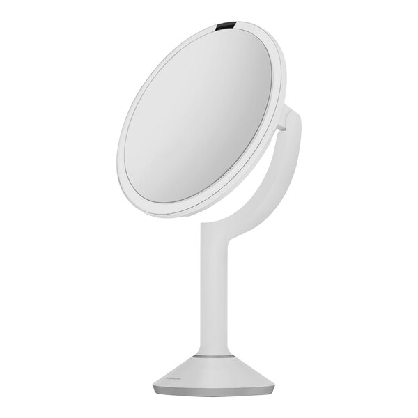A white circular mirror with a white pole on a stand.