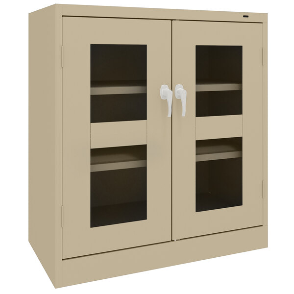 A tan metal Tennsco storage cabinet with C-Thru glass doors.