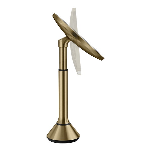 A simplehuman stainless steel sensor mirror with a brass metal stand and round screen.