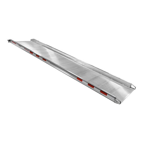 A silver B&P Manufacturing walk ramp with apron ends on a long flatbed trailer.