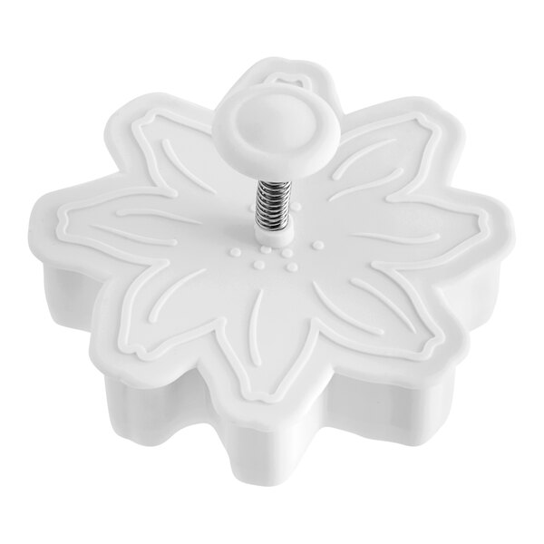 A white plastic Ateco flower-shaped pastry cutter with a screw.