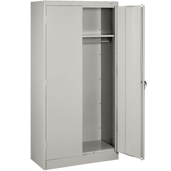 A light gray steel Tennsco wardrobe cabinet with two open doors.