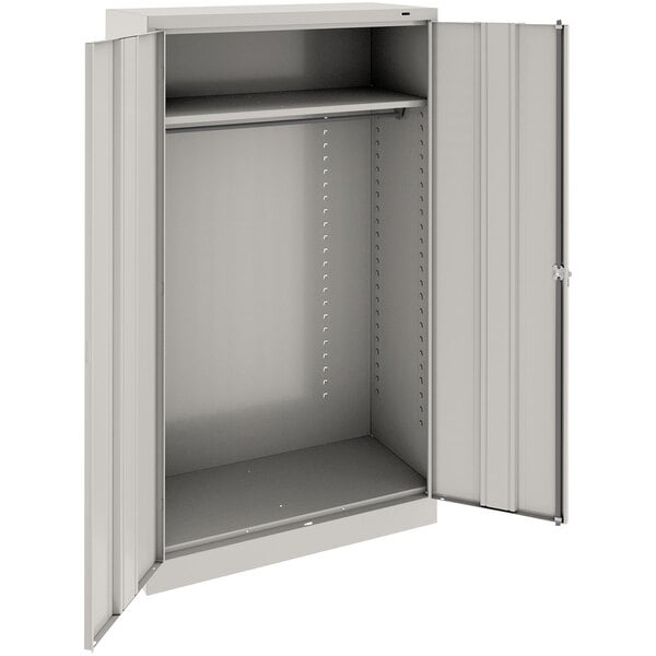 A light gray metal Tennsco wardrobe cabinet with open solid doors.