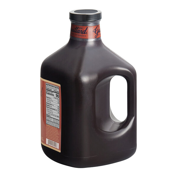 A case of four 101 fl. oz. bottles of Guittard Sweet Ground Dark Chocolate Flavoring Sauce with a handle and label.