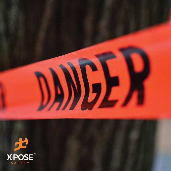 A close up of Xpose Safety "Danger" tape with red and black text on a white background.