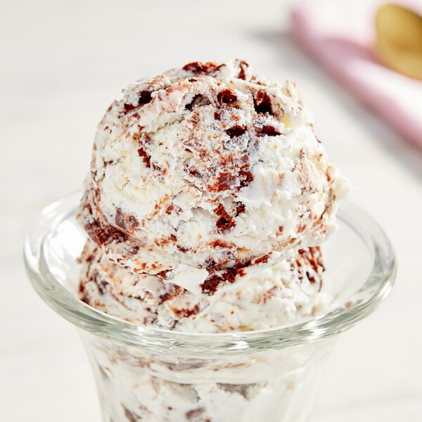 A scoop of white ice cream with brownie bites.
